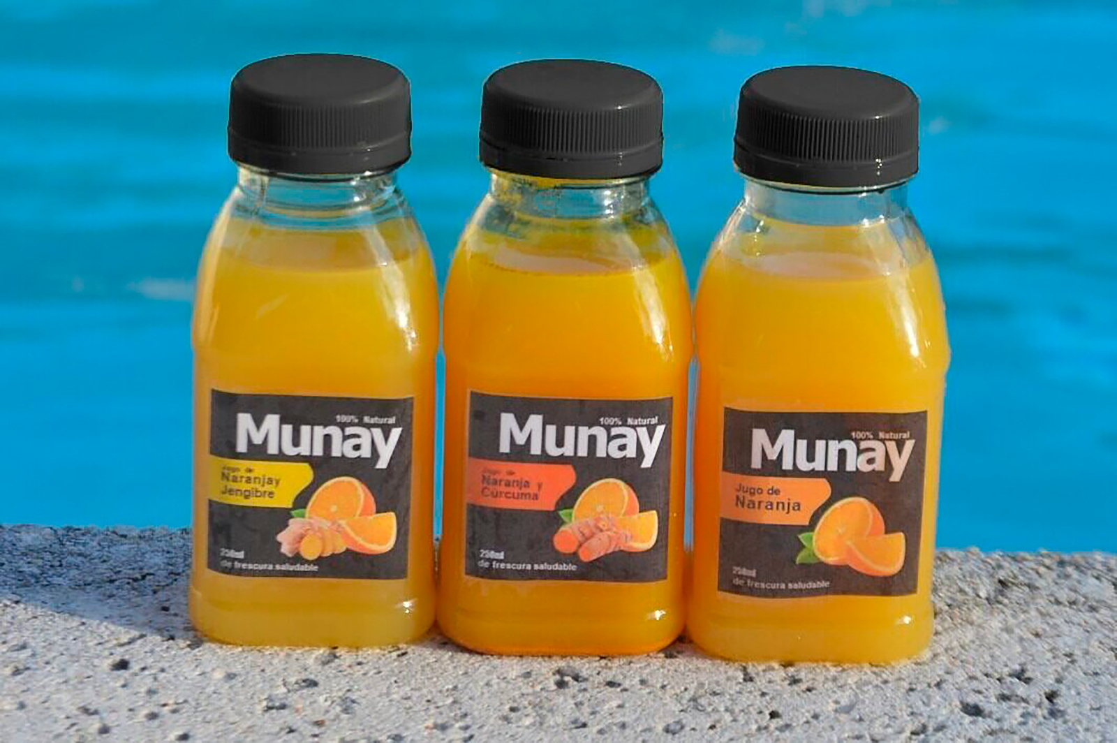 Tres botellas de zumo MUNAY de naranja y jengibre, naranja y curcuma, y naranja.